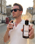 Man applying OPUX perfume outdoors