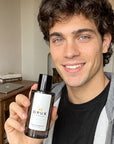 Man holding an OPUX designer inspired perfume bottle
